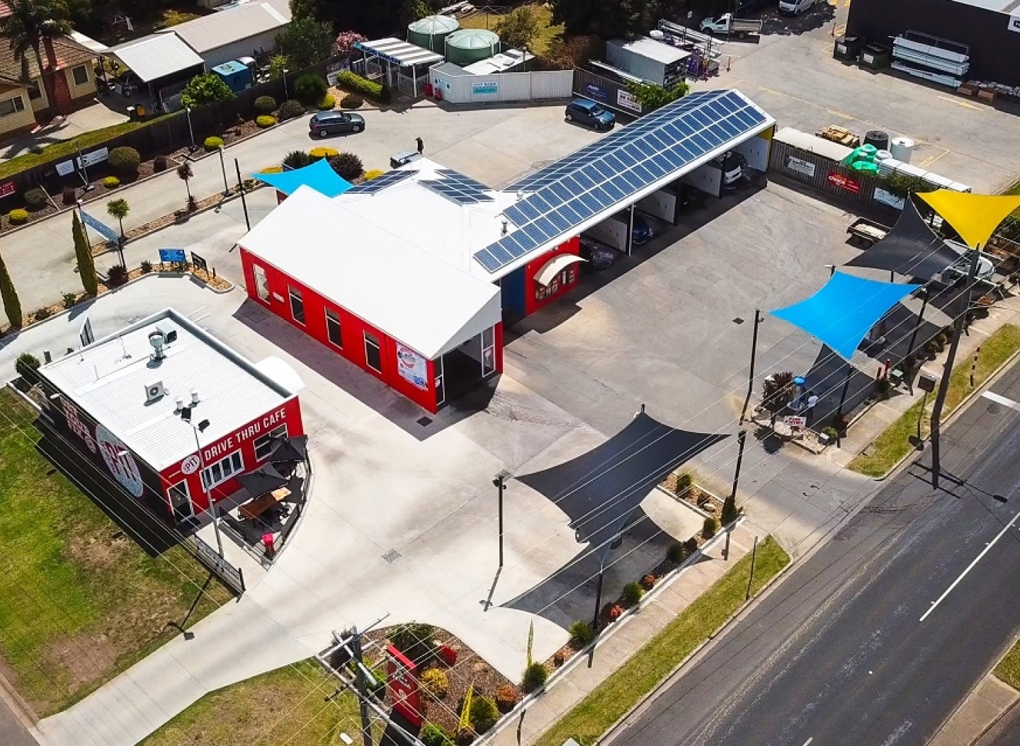 Aerial photo of a car wash sales and advisory business for sale featuring an adjacent drive through coffee shop